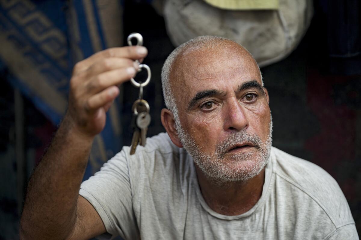 Hassan Nofal, 53, holds the keys to his house that he was forced to leave with his family in Gaza.