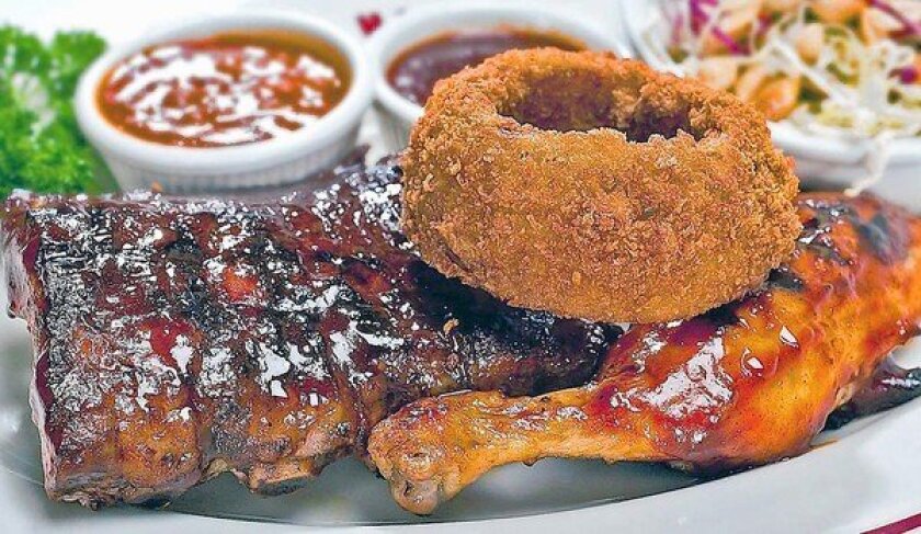 A combination plate with ribs, chicken and onion rings at Smoke House in Burbank. You can catch a deal on dinners before 6 p.m. Mondays to Saturdays.