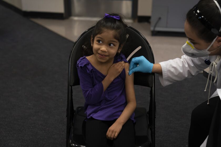 FILE - Elsa Estrada, 6, smiles at her mother as pharmacist Sylvia Uong applies an alcohol swab to her arm before administering the Pfizer COVID-19 vaccine at a pediatric vaccine clinic for children ages 5 to 11 set up at Willard Intermediate School in Santa Ana, Calif., Nov. 9, 2021. As of Tuesday, Jan. 11, 2022, just over 17% of children in the U.S. ages 5 to 11 were fully vaccinated, more than two months after shots for them became available. (AP Photo/Jae C. Hong, File)