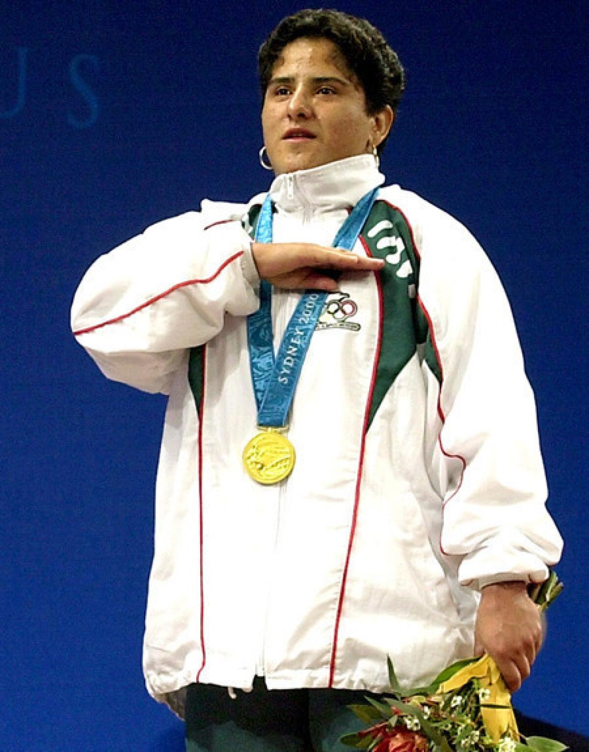Weightlifter Soraya Jimenez salutes from the victory stand as the national anthem of Mexico plays after she received her gold medal at the 2000 Sydney Olympics.