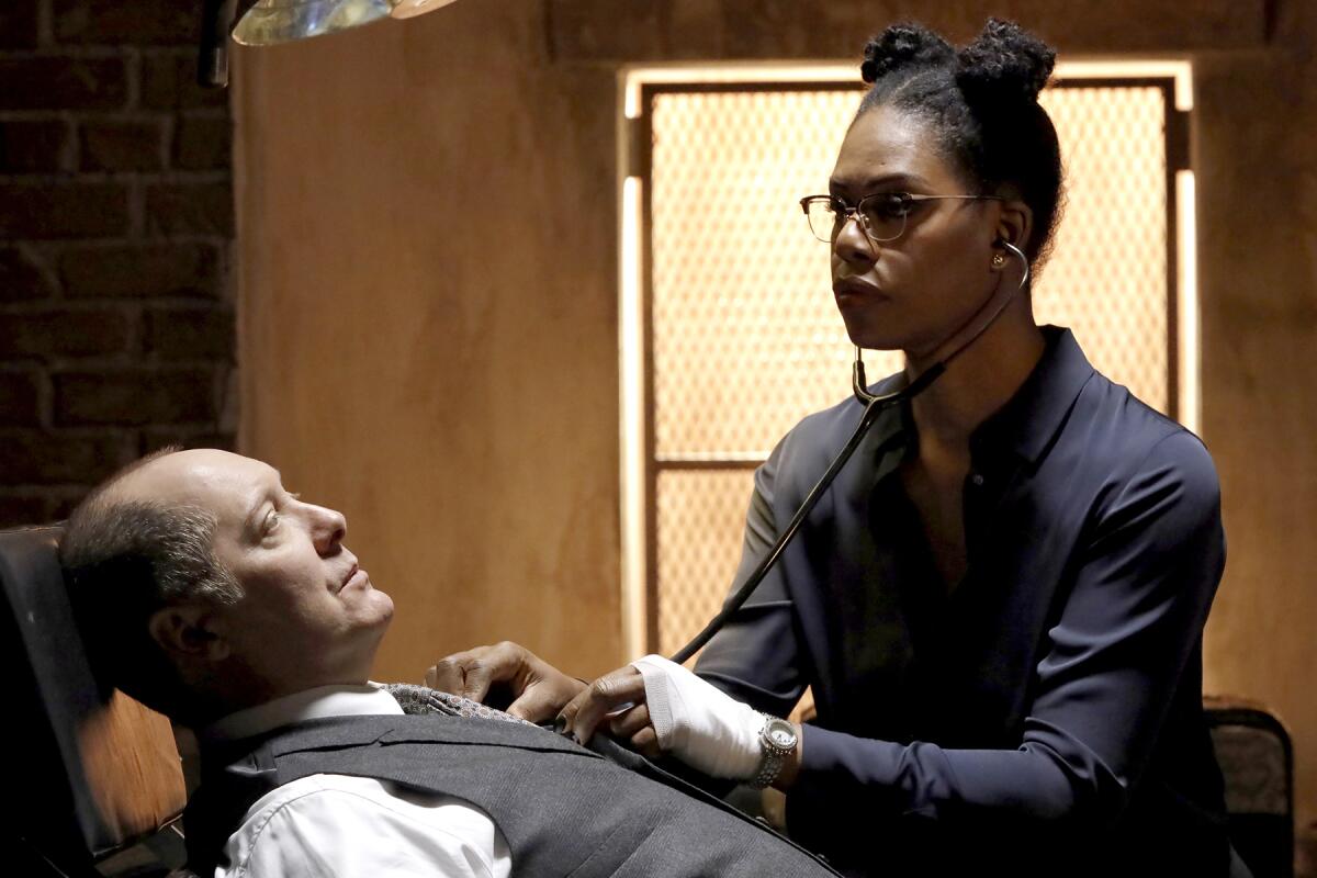 Laverne Cox uses a stethoscope on James Spader in "The Blacklist" on NBC.