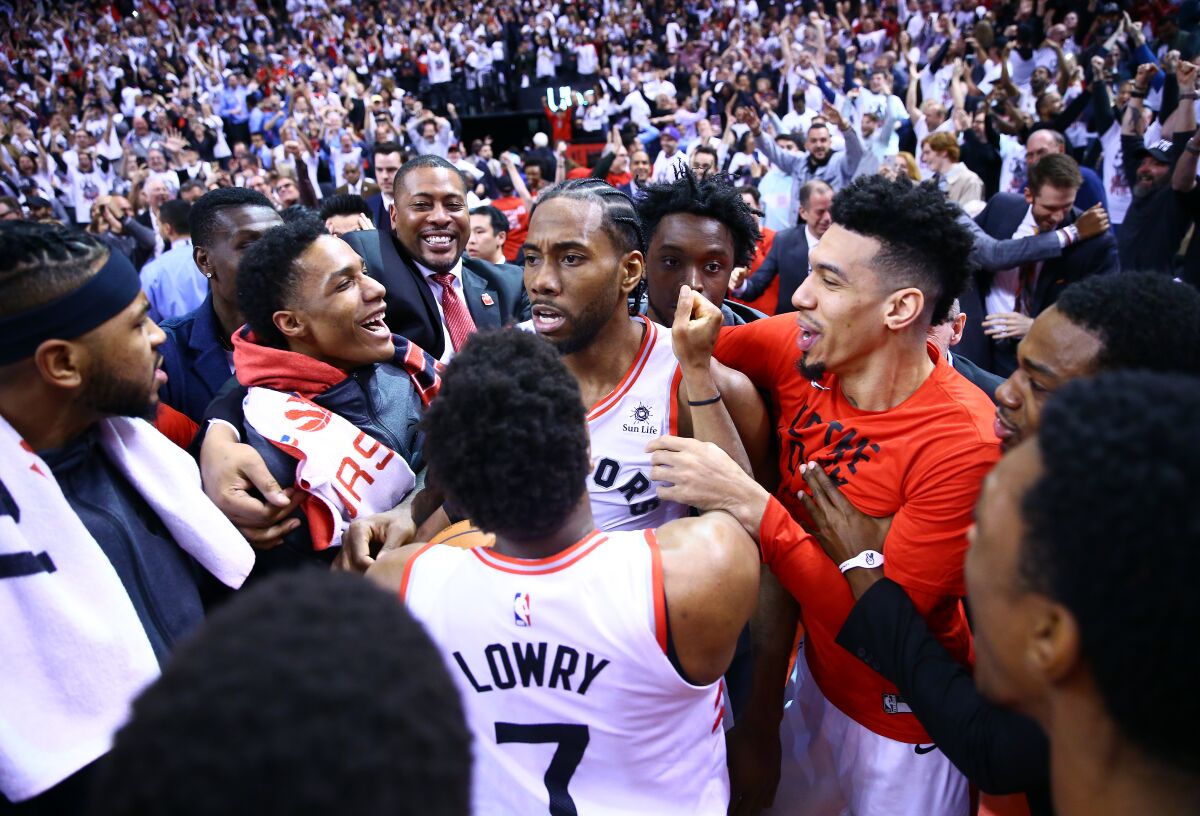 Raptors forward Kawhi Leonard is surrounded by his teammates after making the winning shot against the 76ers during Game 7 of the Eastern Conference semifinals on May 12.