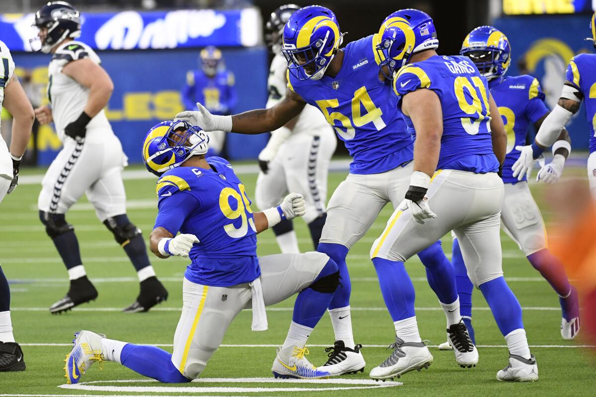 Los Angeles Rams defensive end Aaron Donald, bottom left, celebrates after a defensive stop.