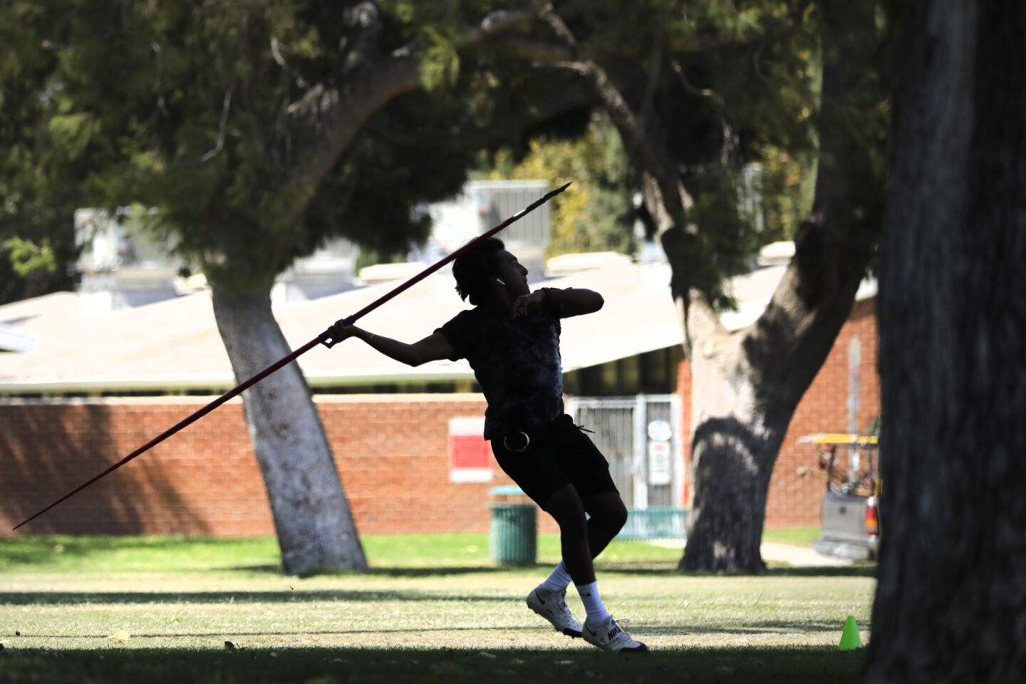 Chris Ruiz finds a shady spot to practice his javelin throw.