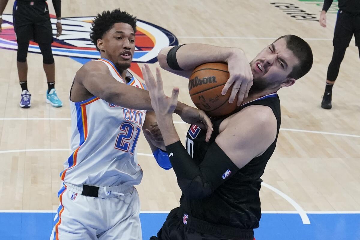 Oklahoma City Thunder guard Aaron Wiggins battles Clippers center Ivica Zubac for a rebound.