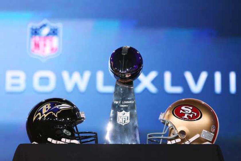 Super Bowl XLVII: The Baltimore Ravens vs. the San Francisco 49ers: Sunday 3:25 p.m. CBS. Pictured: The Vince Lombardi Trophy and team helmets.
