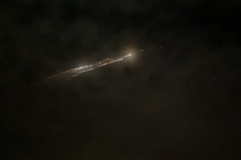 In this image taken from video provided by Roman Puzhlyakov, debris from a SpaceX rocket lights up the sky behind clouds over Vancouver, Wash. Thursday evening, March 25, 2021. The remnants of the second stage of the Falcon 9 rocket left comet-like trails as they burned up upon re-entry in the Earth's atmosphere according to a tweet from the National Weather Service. (Roman Puzhlyakov via AP)