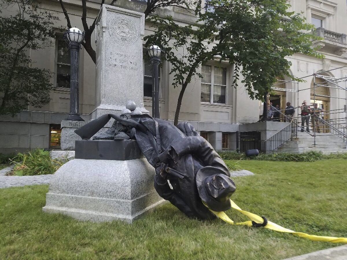 A toppled Confederate statue lies on the ground on Monday, Aug. 14, 2017, in Durham, N.C. Activists used a rope to pull down the monument outside a Durham courthouse. The Durham protest was in response to a white nationalist rally held in Charlottesville, Va, over the weekend.