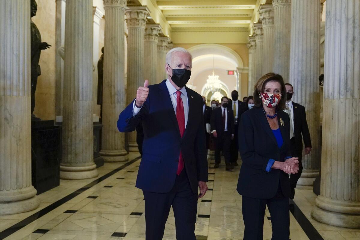 President Biden gives a thumbs-up as he walks with House Speaker Pelosi on Capitol Hill