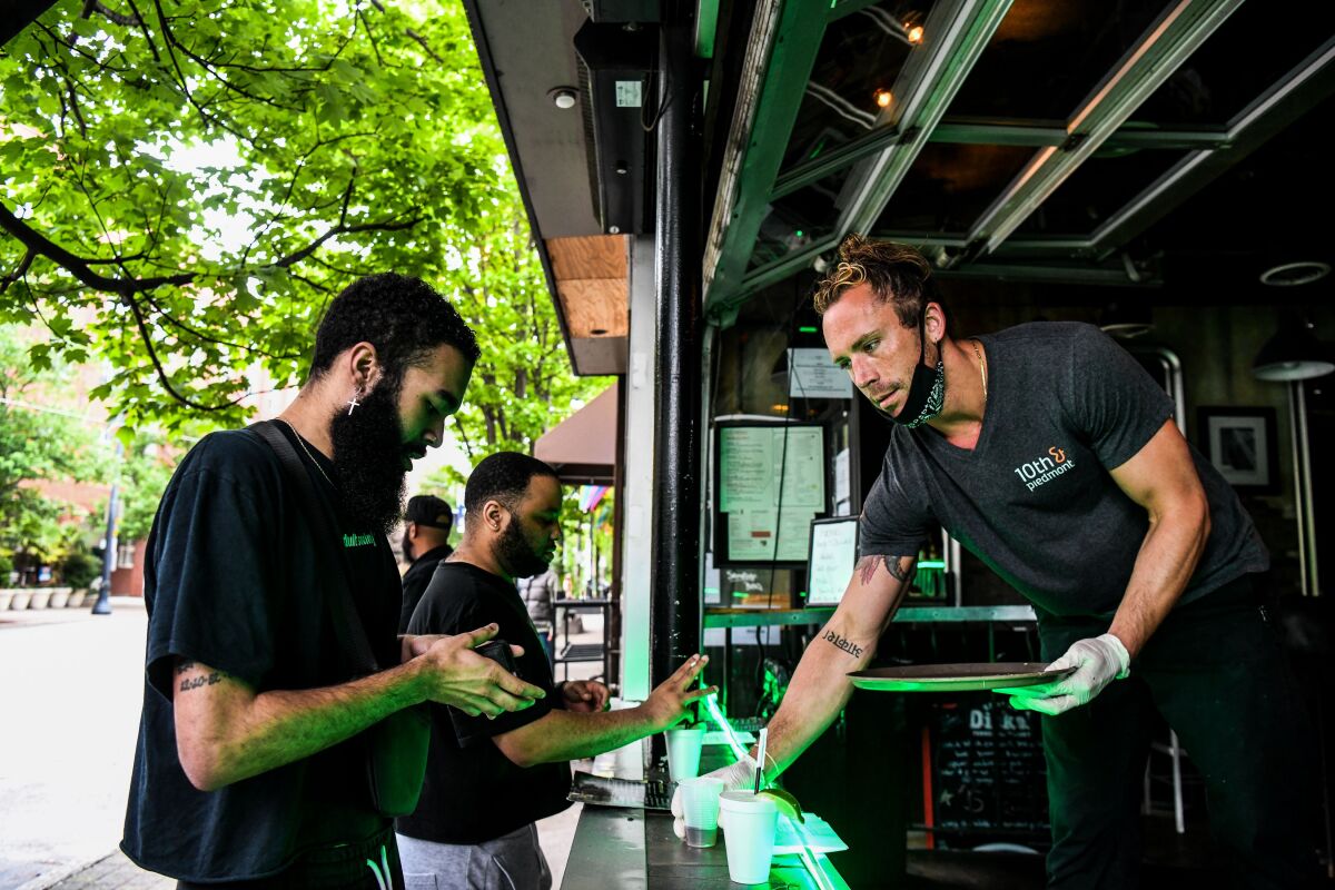 Bartender Jake Glazier serves customers at a reopened roadside bar in Atlanta