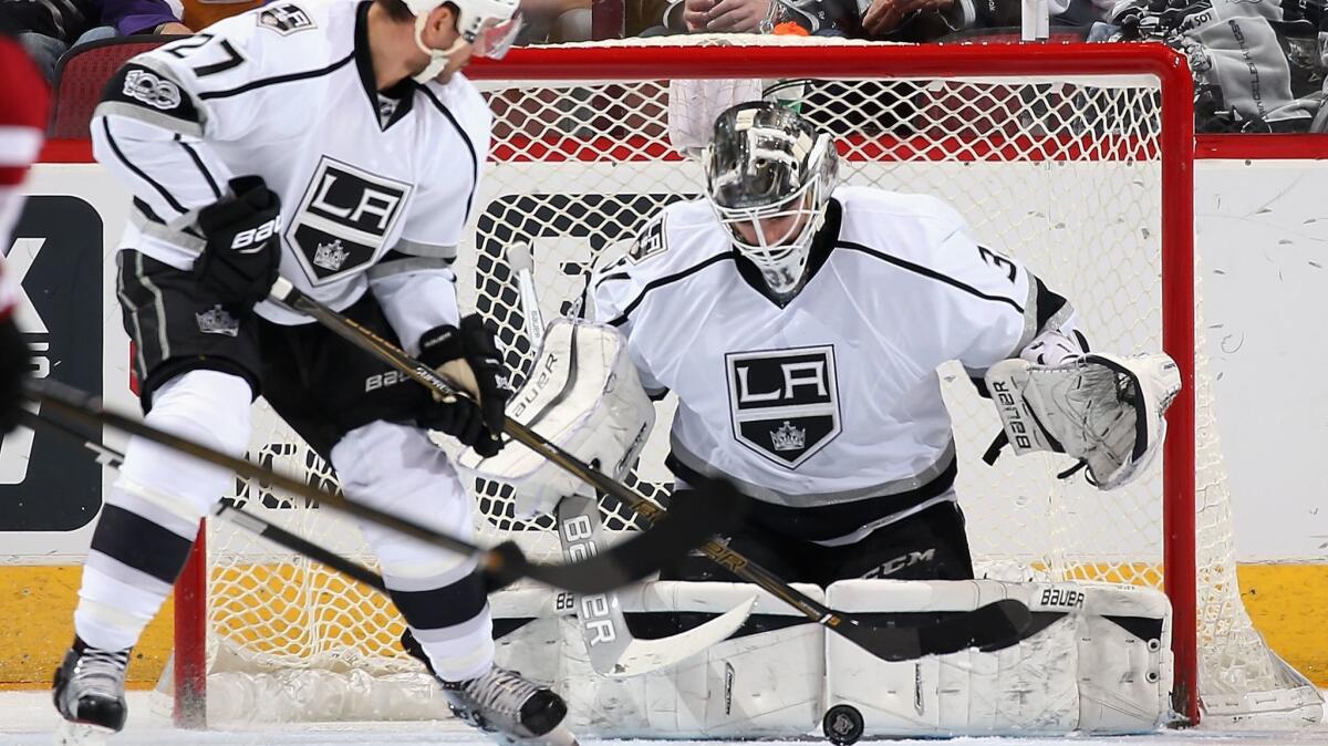 Kings goalie Peter Budaj makes a save as teammate Alec Martinez looks to clear on Jan. 31.