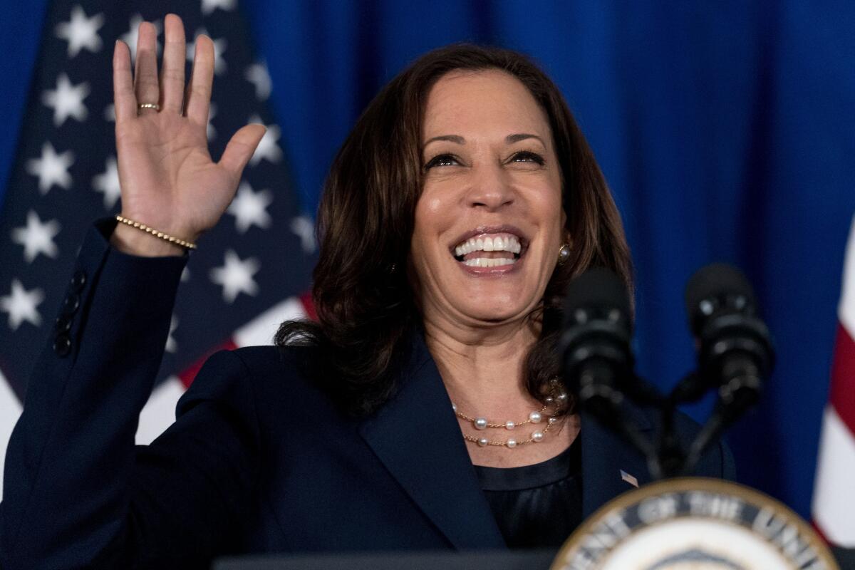 Vice President Kamala Harris waves from a lectern