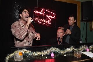 Darren Criss and Oscar-winning composers Benj Pasek and Justin Paul sing in front of a piano