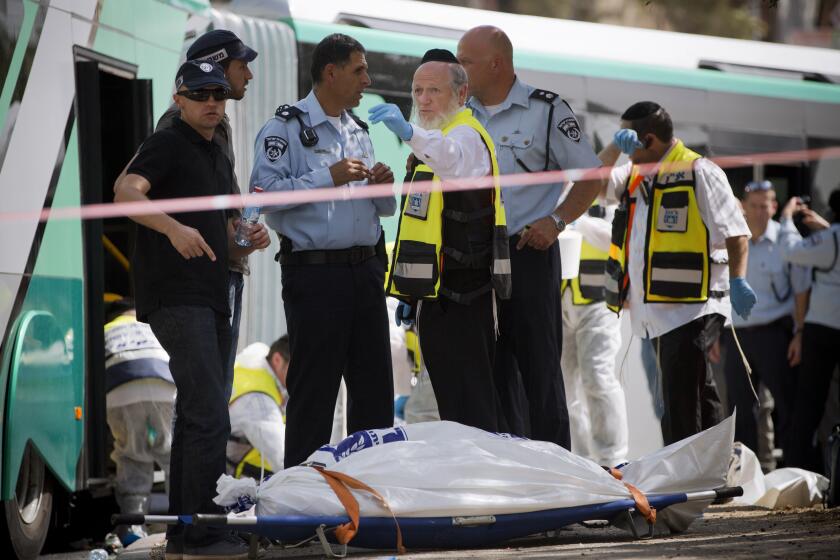 FILE - In this Oct. 13, 2015 file photo, Yehuda Meshi-Zahav, then head of Israel's ZAKA rescue service, center, stands next to the body of an Israeli killed in a shooting by a Palestinian attacker, in Jerusalem. On Sunday, March 14, 2021, the Israeli police announced that the force's major crimes unit, Lahav 433, had opened an investigation into sexual abuse allegations against Meshi-Zahav. In recent days, some 20 people have come forward with claims that he was a savage sexual predator who assaulted men, women and children for years. (AP Photo Oded Balilty, File)