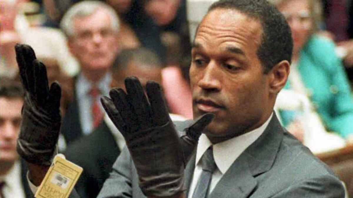 O.J. Simpson mira un nuevo par de guantes extragrandes, que los fiscales le hicieron probar durante su juicio por doble asesinato, en Los Ángeles. El proceso inspiró una muestra temporaria en una galería, llamada “The O.J. Simpson Museum” (Vince Bucci / AFP / Getty Images).