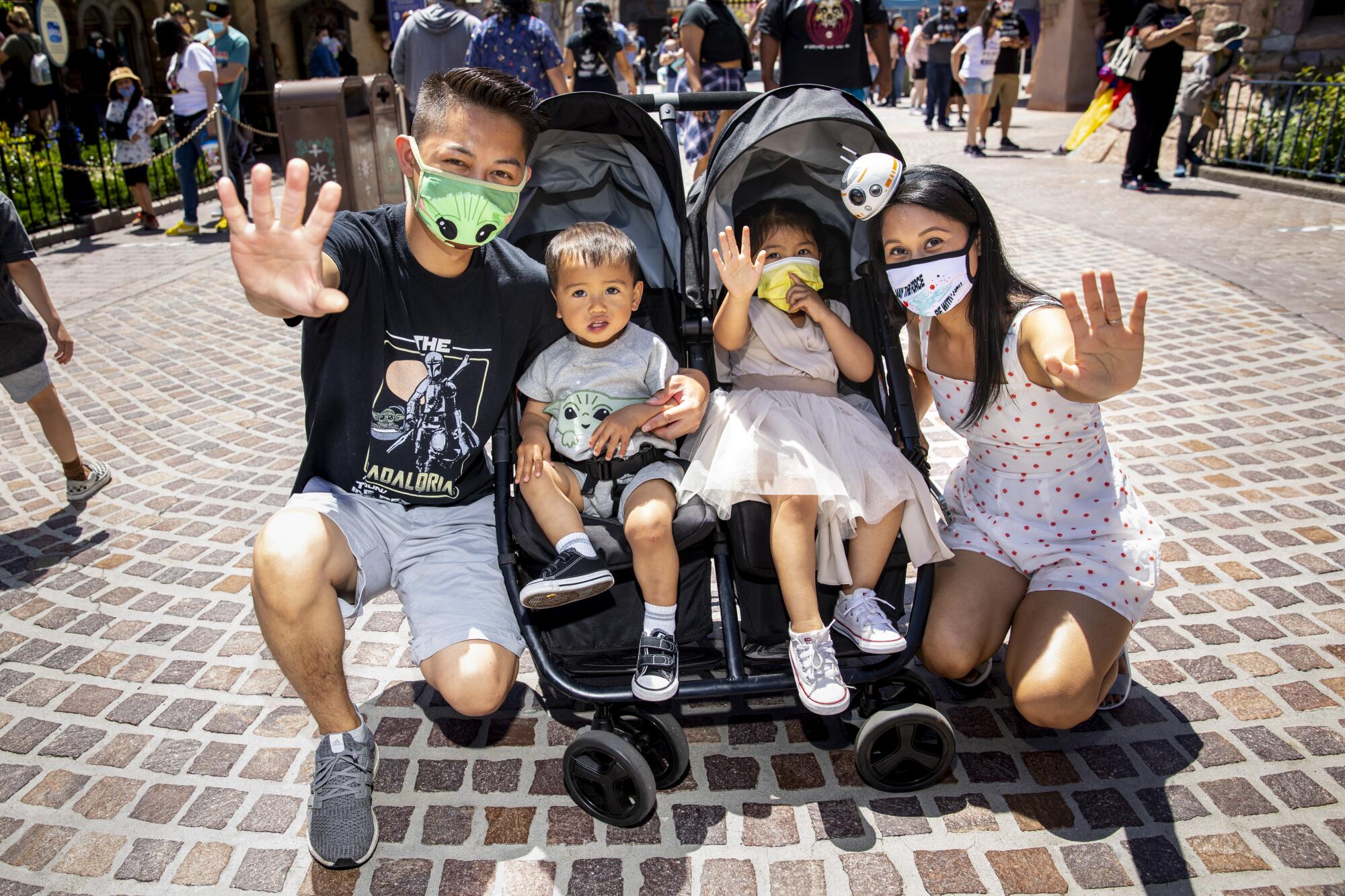 A family in "Star Wars" gear holds up their hands as if using the Force