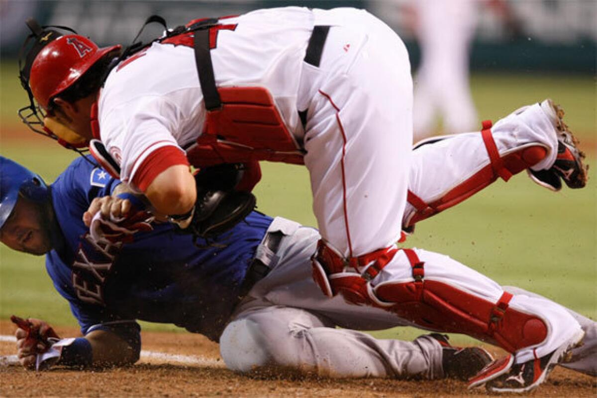Former Angels catcher Bobby Wilson, shown colliding with another ex-Angels catcher, Texas' Mike Napoli, has been claimed off waivers by Toronto, where Wilson will join yet another former Angels catcher, Jeff Mathis.