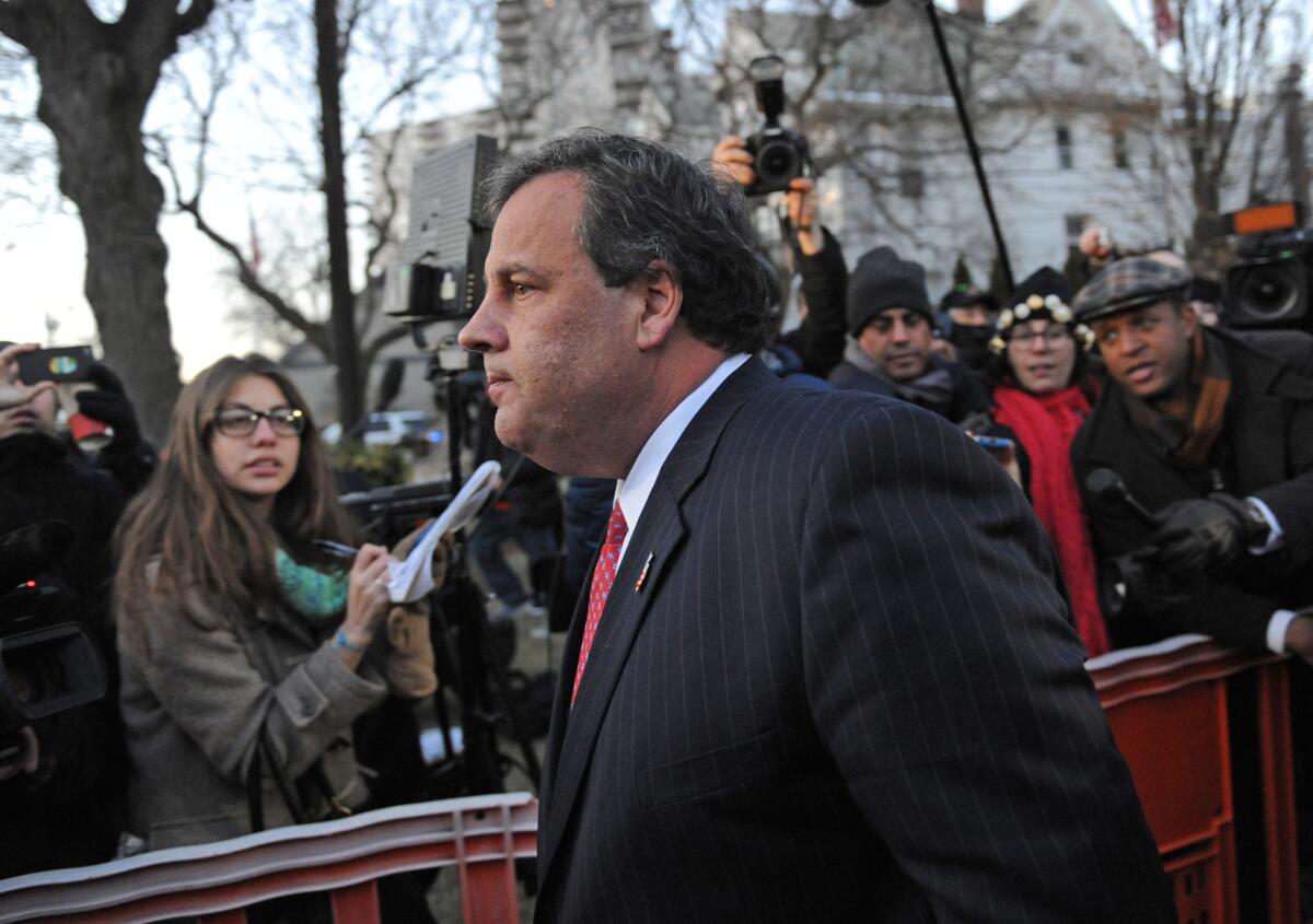 New Jersey Gov. Chris Christie walks past reporters as he leaves City Hall, in Fort Lee, N.J., after apologizing in person to Mayor Mark Sokolich. Moving quickly to contain a widening political scandal, Christie fired one of his top aides Thursday and apologized repeatedly for the "abject stupidity" of his staff, insisting he had no idea anyone around him had engineered traffic jams to get even with Sokolich for not supporting his re-election campaign.