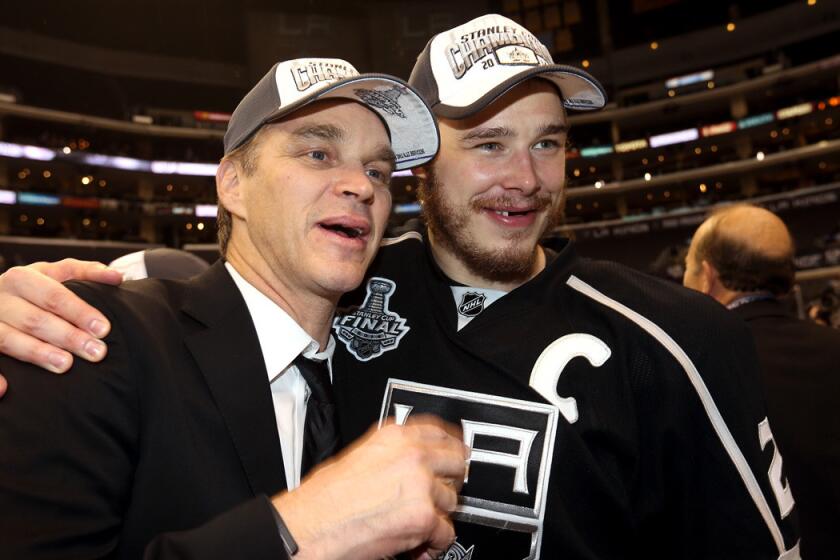 Former Kings star Luc Robitaille, left, now the club's president of business operations, and captain Dustin Brown celebrate after the Kings clinched their second Stanley Cup championship in three seasons.