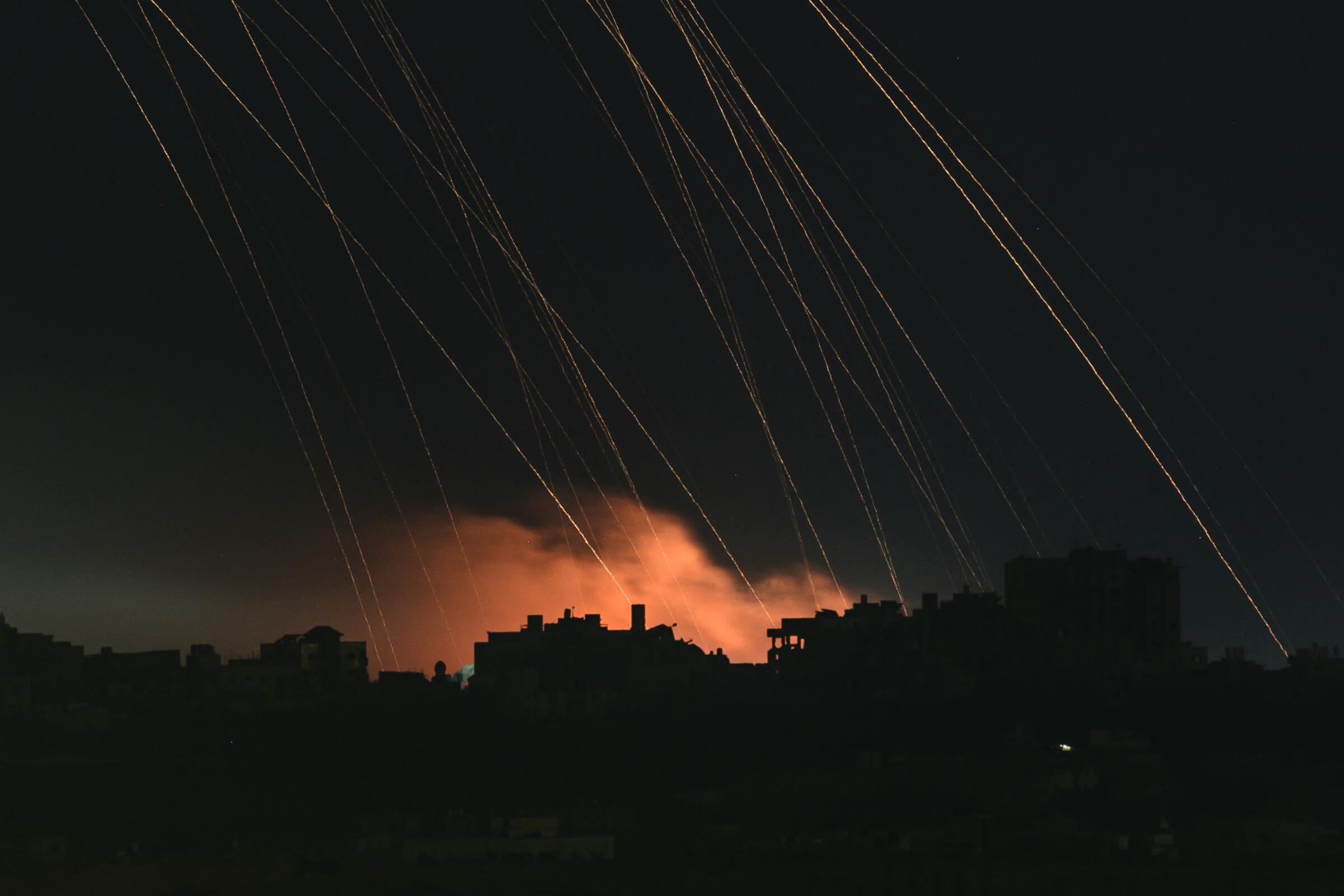 A long exposure picture taken from southern Israel near the Gaza border shows Israeli shells falling on the north Gaza Strip.