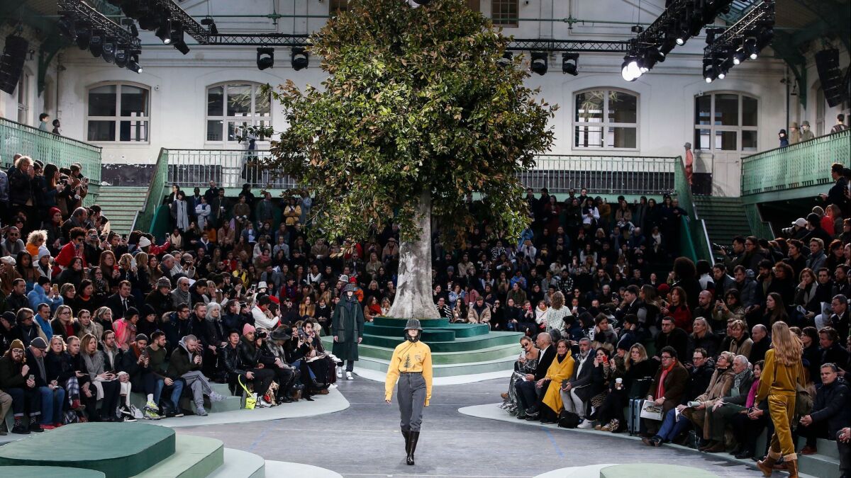 A tree towers at the top of the runway at Lacoste's fall/winter 2018 men's and women's runway collection show on Feb 28. The tree is a reference to the collection's inspiration -- 50,000 WWII-era trees planted at the behest of label namesake Rene Lacoste.