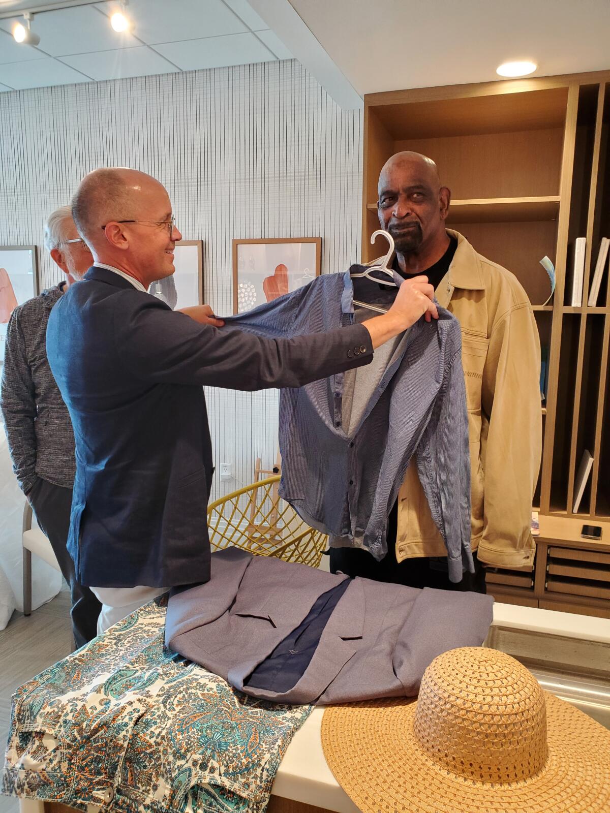 Belmont Village La Jolla manager James Arp looks to see whether a shirt will fit resident Dwight McDonald. 