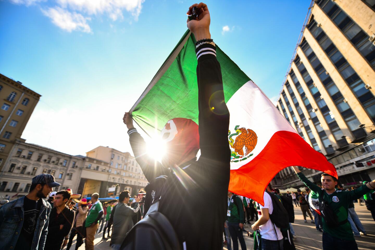Un enmascarado aficionado mexicano ondea su bandera por el centro de Moscú.