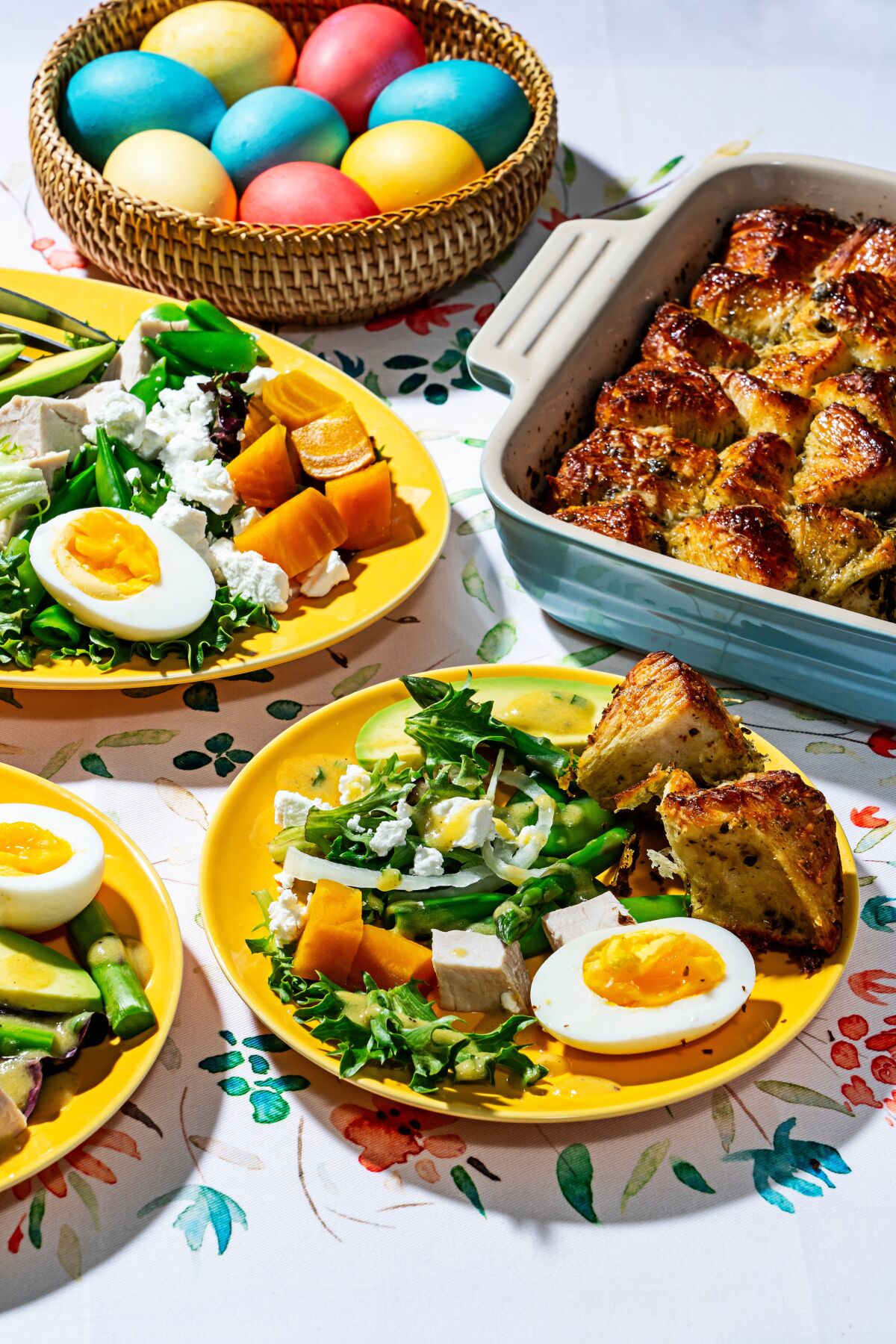 A Cobb salad and monkey bread are shown on bright plates for an Easter brunch.