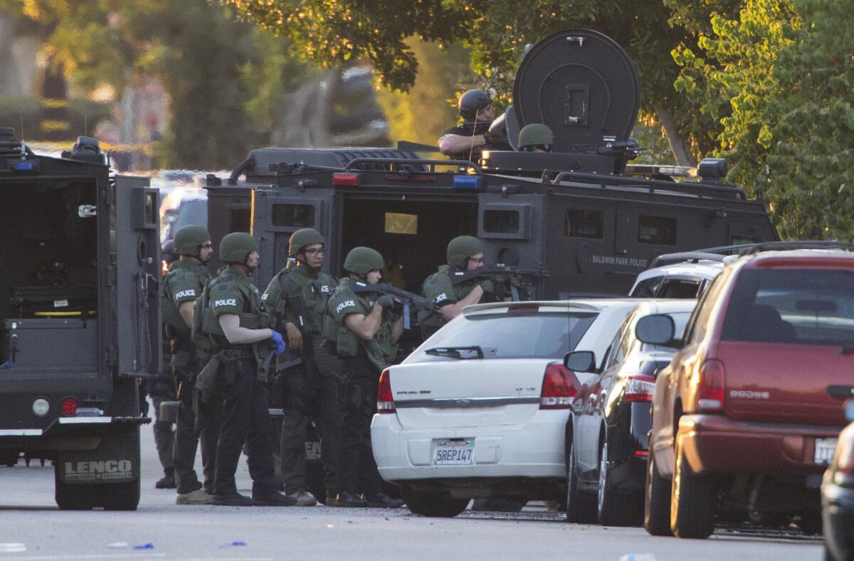 SWAT officers near an Azusa home at the intersection of Orange Avenue and Fourth Street after four people were shot.