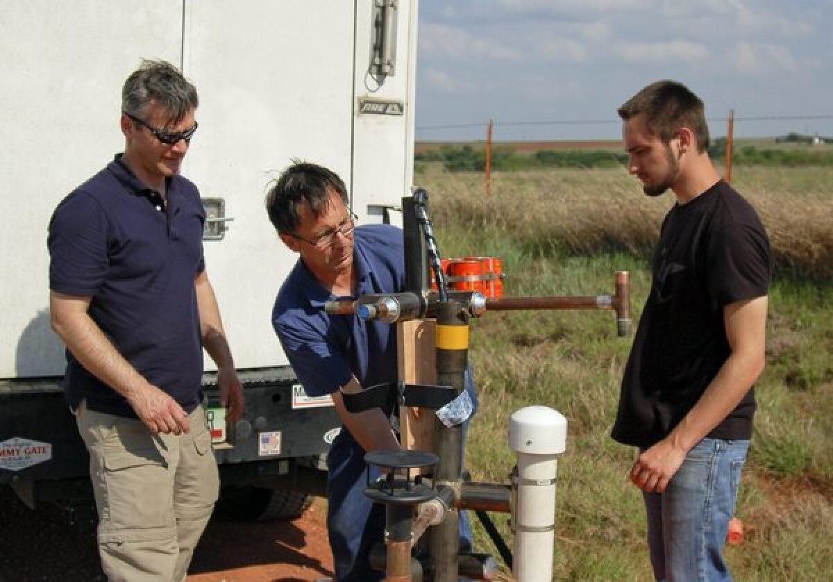Storm chaser Tim Samaras, center, working in the field with Carl Young, left, and his son Paul Samaras.