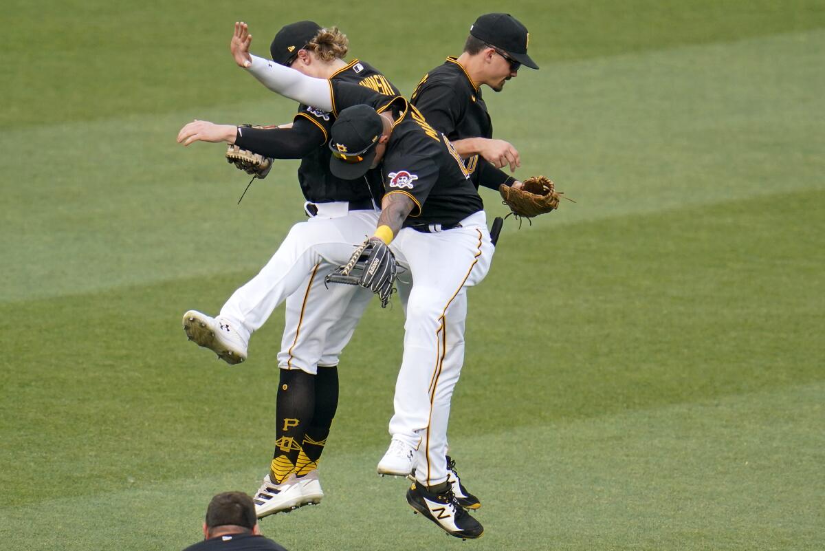 Pittsburgh Pirates outfielders Jack Suwinski, left, Bligh Madris, center, and Bryan Reynolds celebrate after getting the final out of a baseball game against the Milwaukee Brewers in Pittsburgh, Saturday, July 2, 2022. The Pirates won 7-4. (AP Photo/Gene J. Puskar)