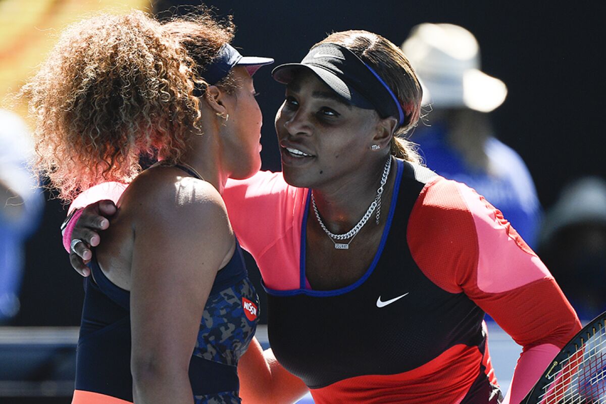 Naomi Osaka and Serena Williams embrace at the net
