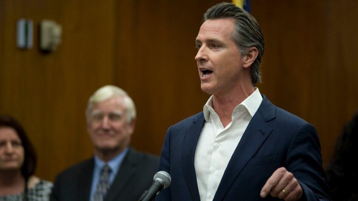 Gov. Gavin Newsom speaks to reporters in San Diego on Jan. 31, 2019, about his proposal to spend $25 million on aid to asylum seekers.