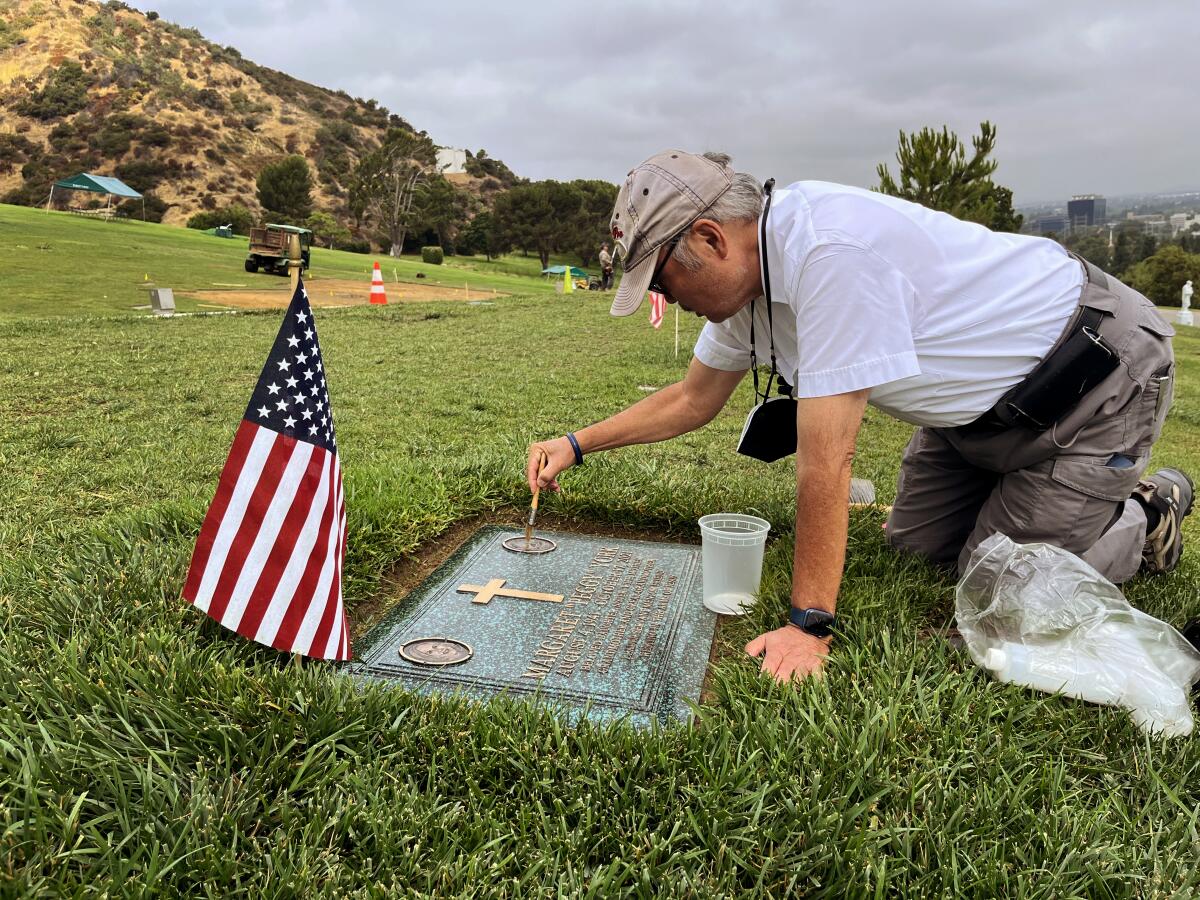 Retired Judge Lance Ito attends to the grave of his wife, Peggy York. 