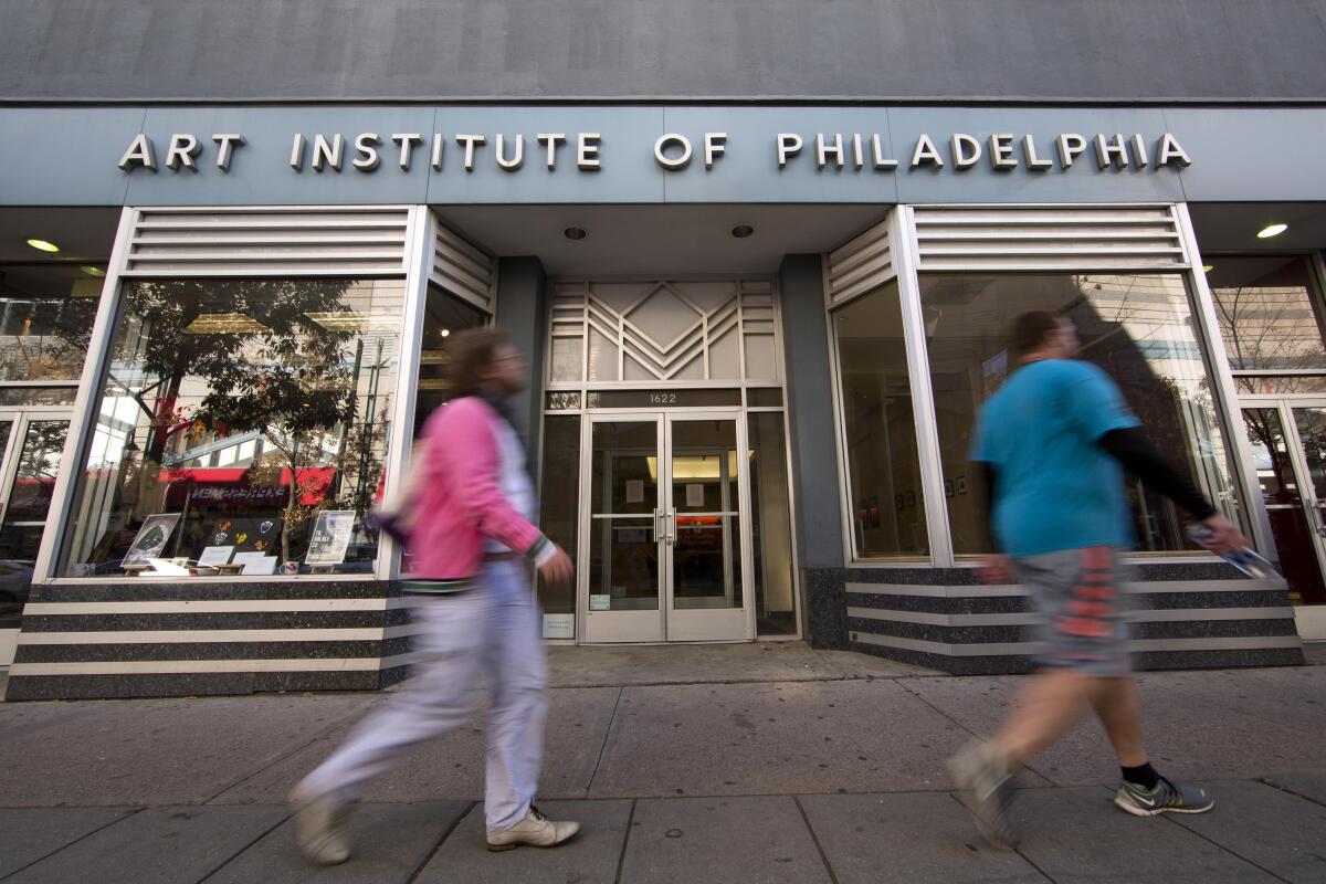 People walk past the Art Institute of Philadelphia 