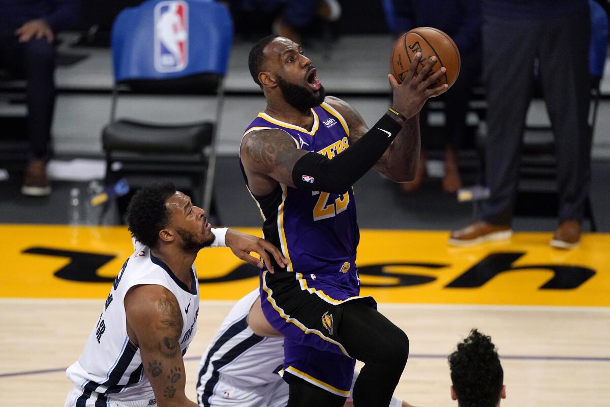 The Lakers' LeBron James drives to the basket past the Memphis Grizzlies' Xavier Tillman on Feb. 12, 2021.