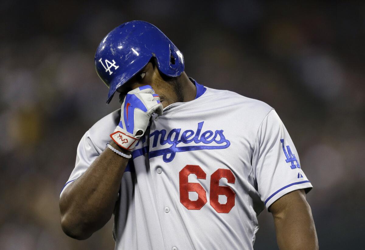 Dodgers outfielder Yasiel Puig wipes his face during a game against the Athletics.