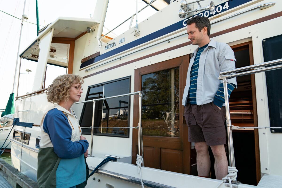 Elijah Wood stands on a boat, talking to Christina Ricci, in "Yellowjackets"
