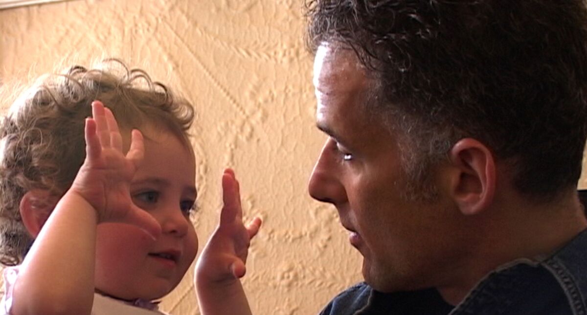 A man holds with his toddler daughter in "How Do You Measure a Year?"