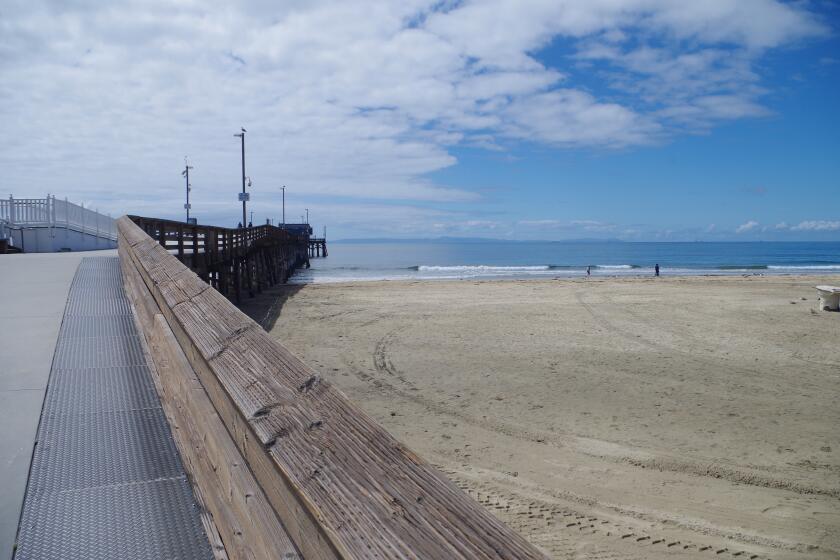 Newport Pier and the surrounding beach are both nearly empty on March 24, 2020.