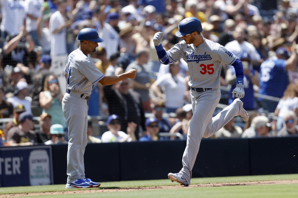 Cody Bellinger celebrates with third base coach Dino Ebel after hitting a home run against the Padres.