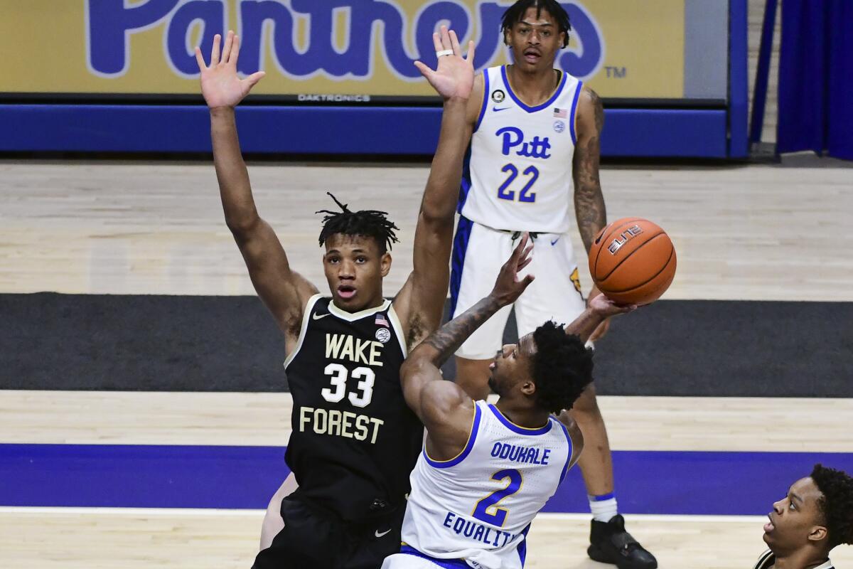 Pittsburgh guard Femi Odukale drives in for a shot against Wake Forest forward Ody Oguama during the first half of an NCAA college basketball game Tuesday, March 2, 2021, in Pittsburgh. (AP Photo/Fred Vuich)