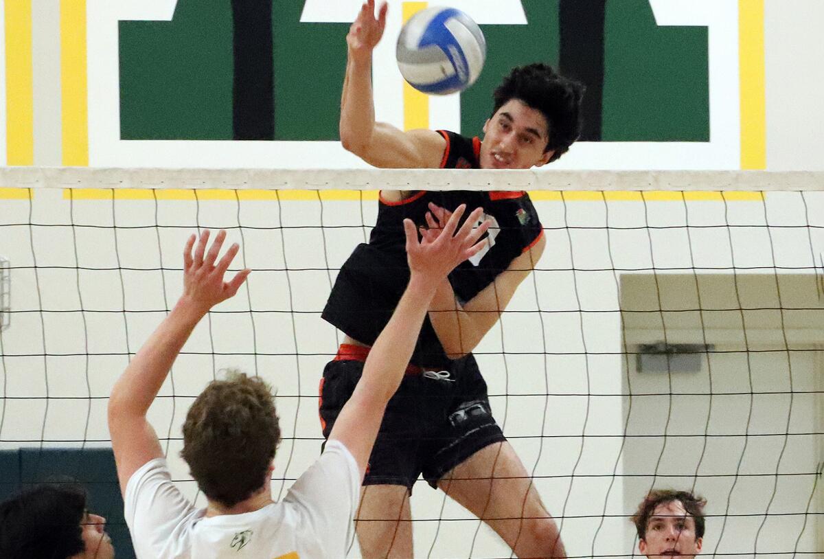 Huntington Beach's Kaegan Ramdhani (0) spikes the ball against Mira Costa on Saturday.