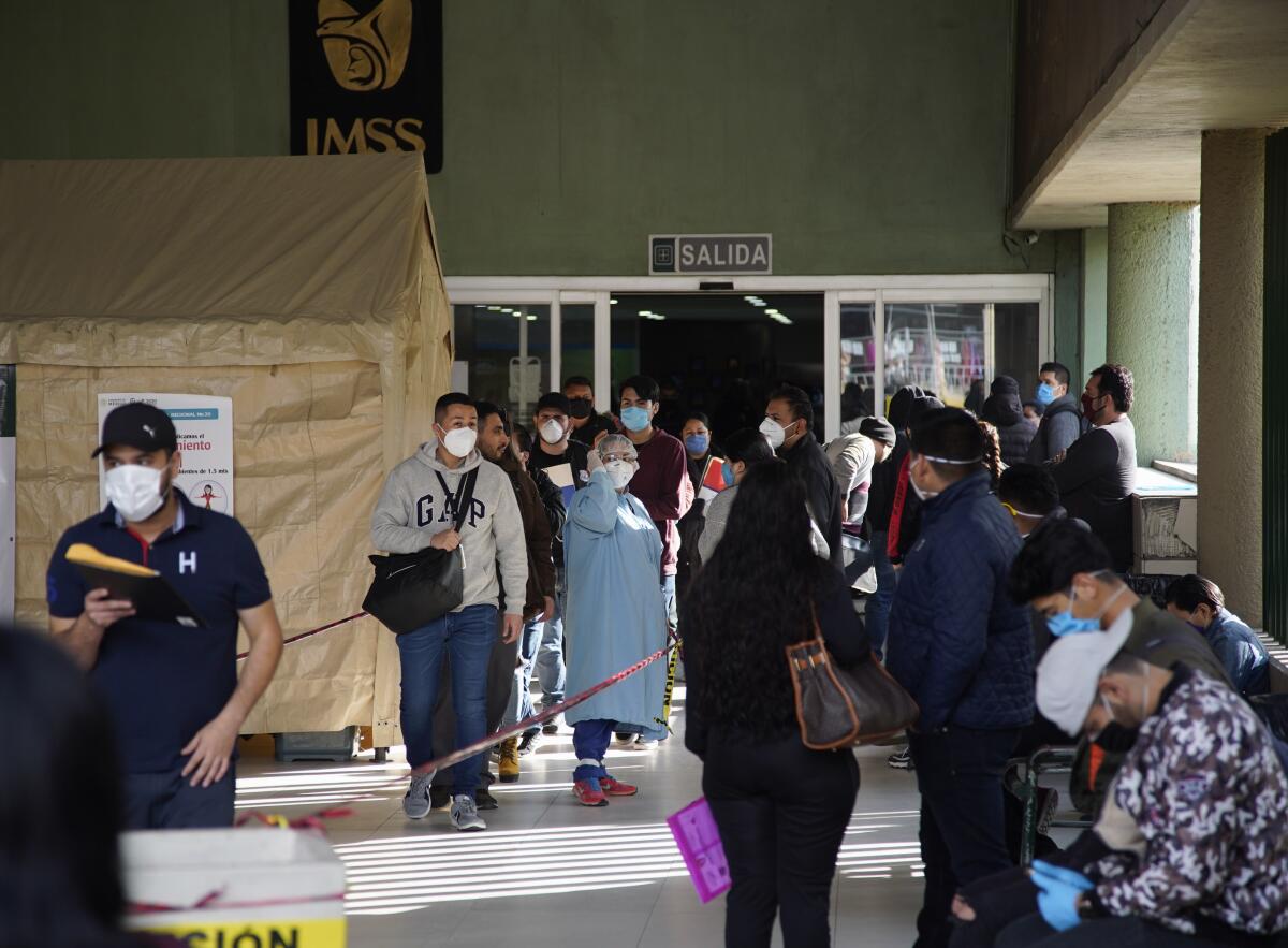 La gente espera fuera del hospital por actualizaciones del personal de la Clínica 20 del IMSS. Solo se permite la entrada a los pacientes, mientras que los visitantes deben esperar fuera.