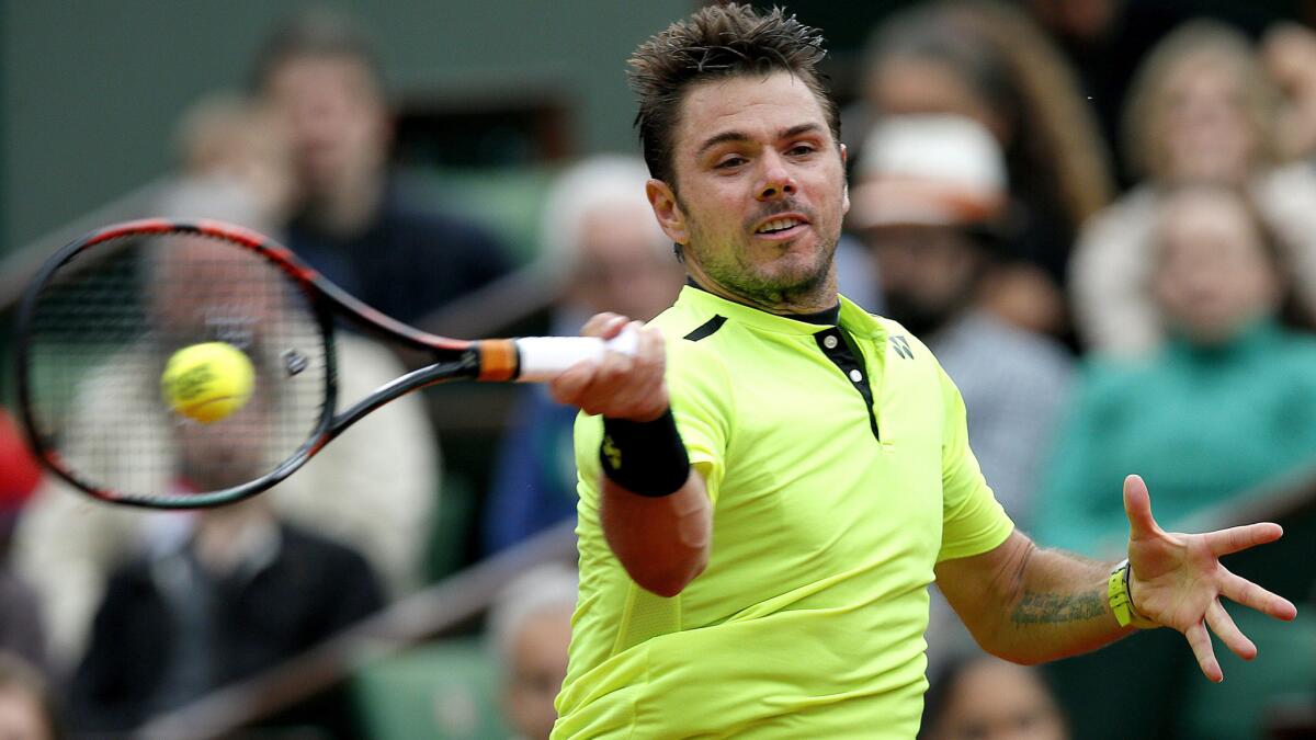 Stan Wawrinka returns a shot against Viktor Troicki during their fourth-round match at the French Open on Sunday.