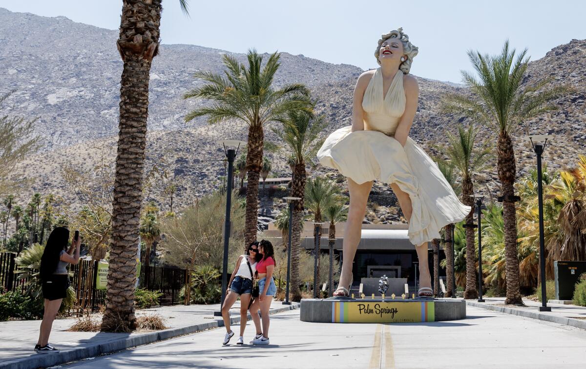 Tourists take photos in front of the Marilyn Monroe statue in Palm Springs.