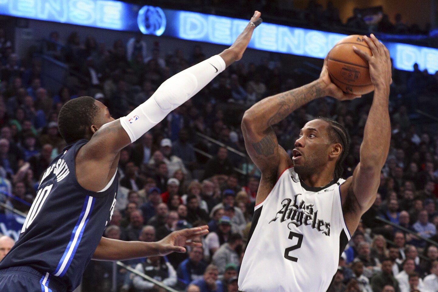 Dallas Mavericks forward Dorian Finney-Smith (10) tries to defend against a shot by Los Angeles Clippers forward Kawhi Leonard (2) during the second half of an NBA basketball game Tuesday, Jan. 21, 2020 in Dallas. (AP Photo/Richard W. Rodriguez)