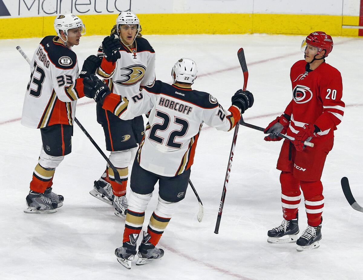 Ducks forward Carl Hagelin, second from left, is congratulated on his goal against the Hurricanes by teammates Jakob Silfverberg (33) and Shawn Horcoff (22).