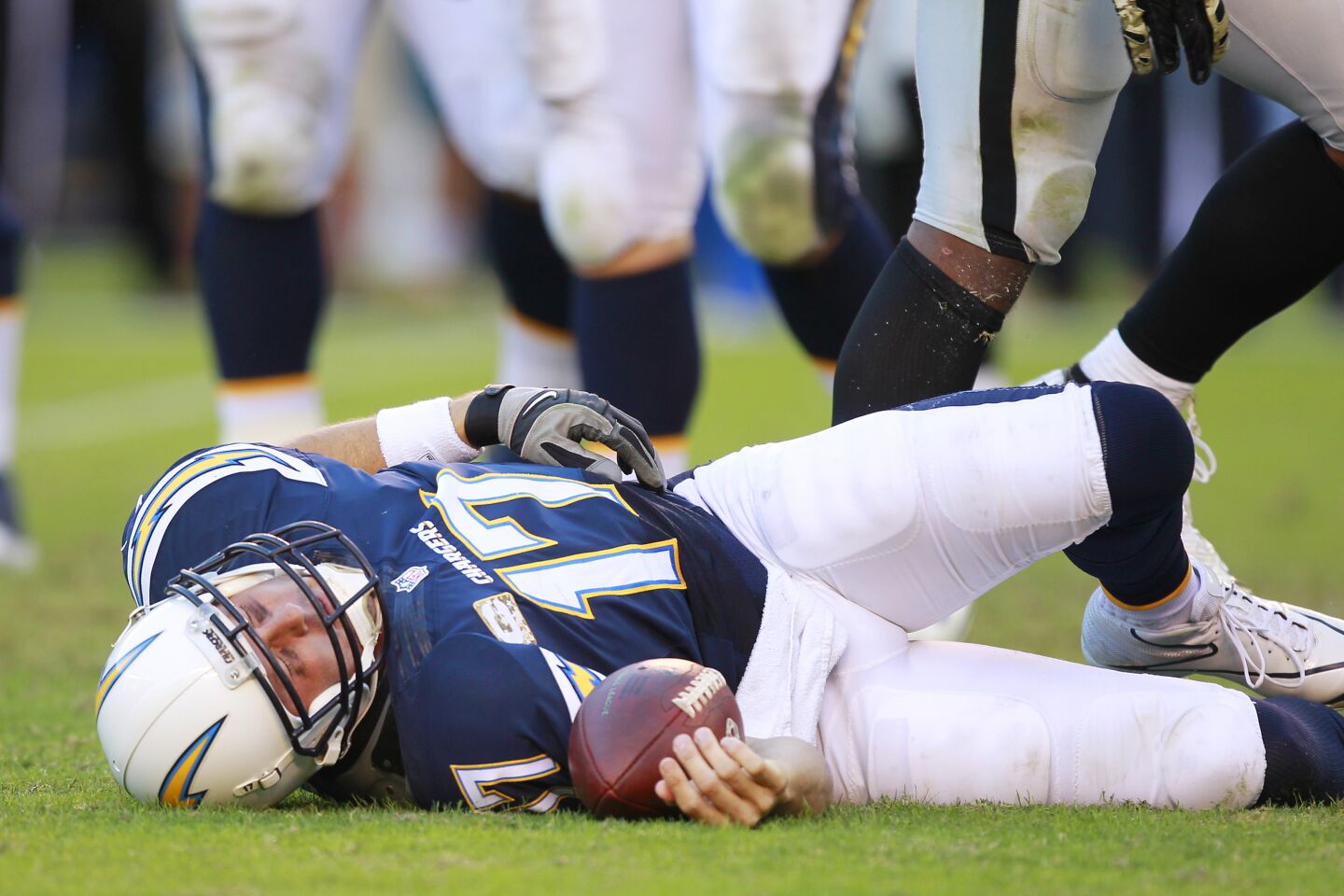 Chargers Philip Rivers grimaces after getting hit by Raiders Khalil Mack in the 4th quarter at Qualcomm Stadium on Nov. 16, 2014.