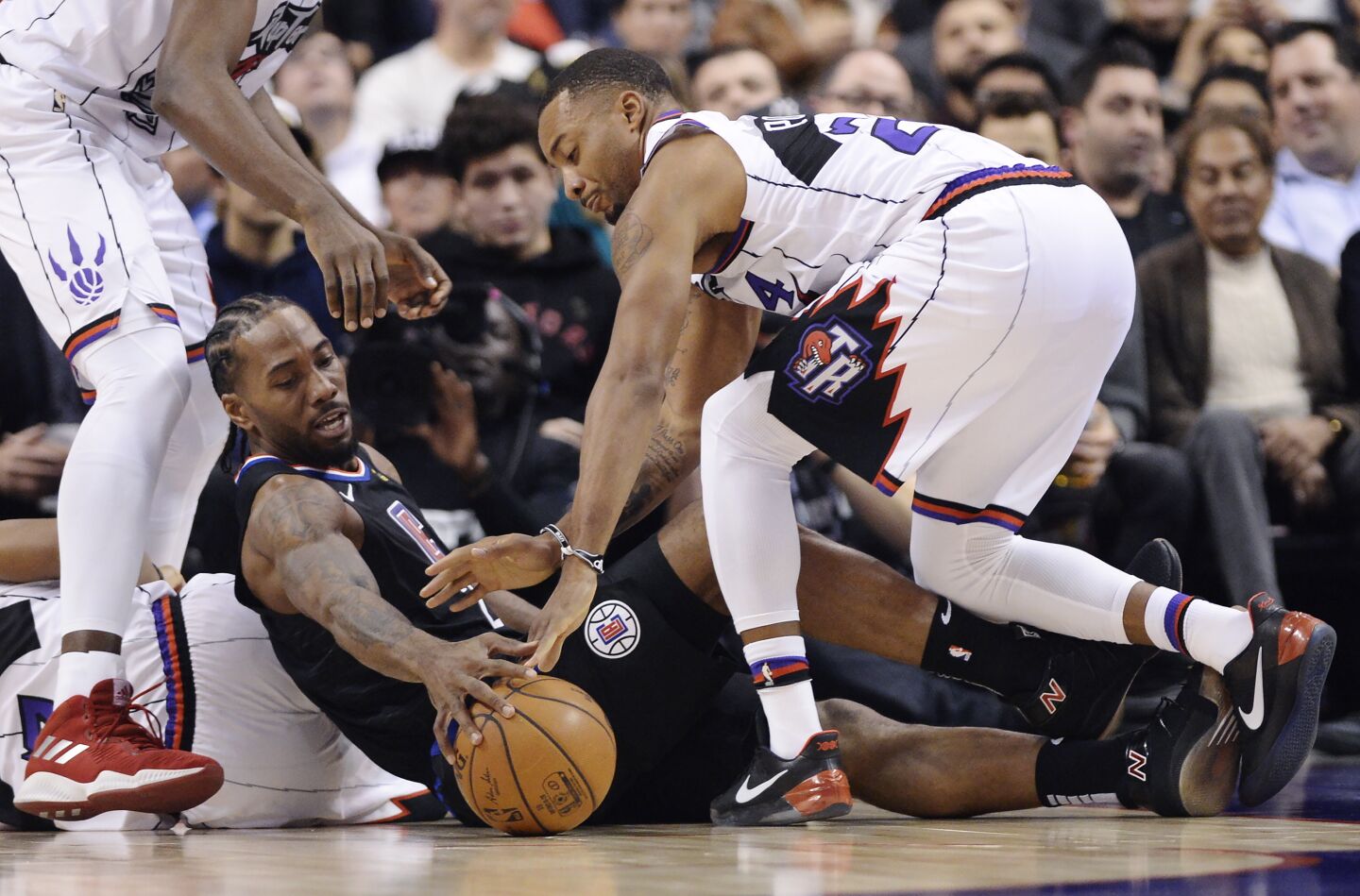Clippers forward Kawhi Leonard (2) and Raptors guard Norman Powell (24) battle for the ball during a game Dec. 11.